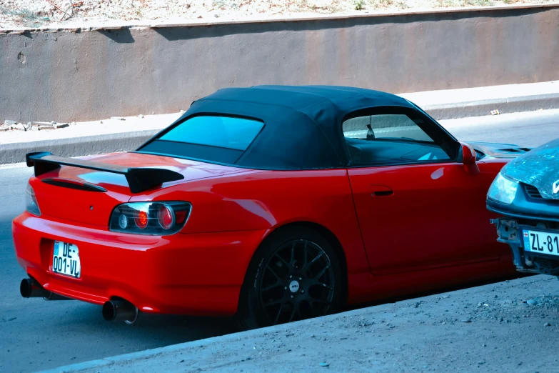 a red and blue sports car parked on the side of the road