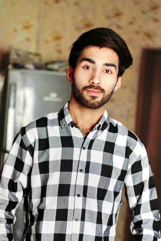 a young man with a beard wearing a shirt