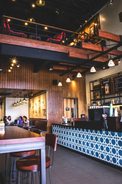 a restaurant with multiple wooden chairs and a colorful tile bar