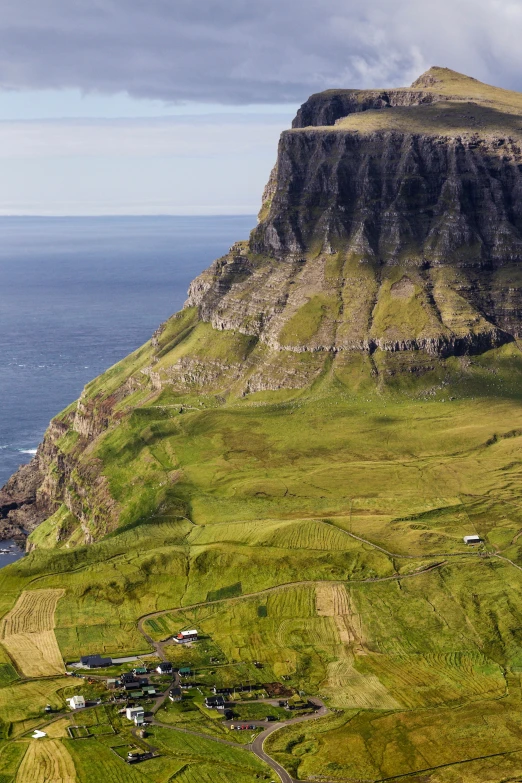 the view of some water and green hills from a height of up