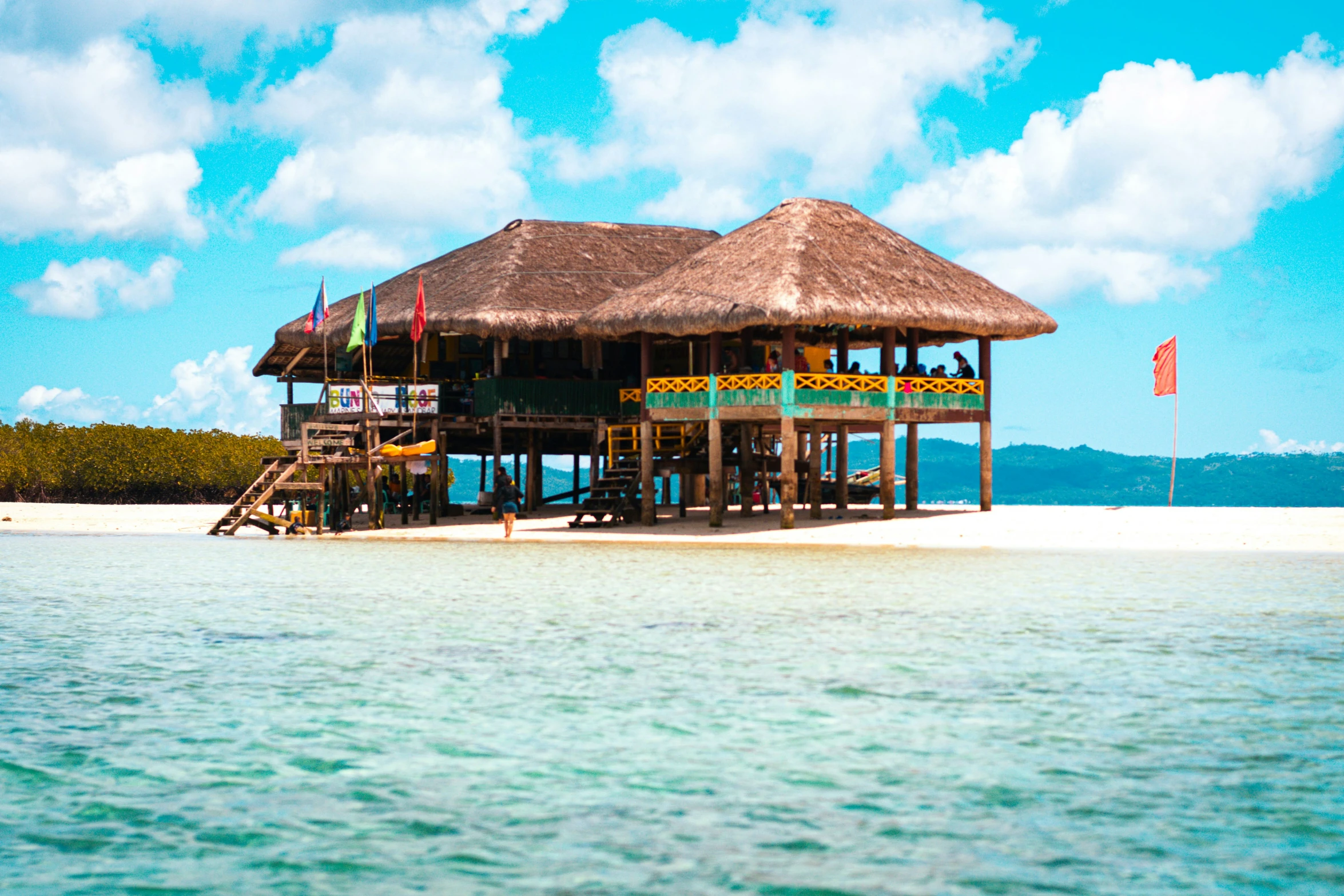 a thatched hut is shown over the water