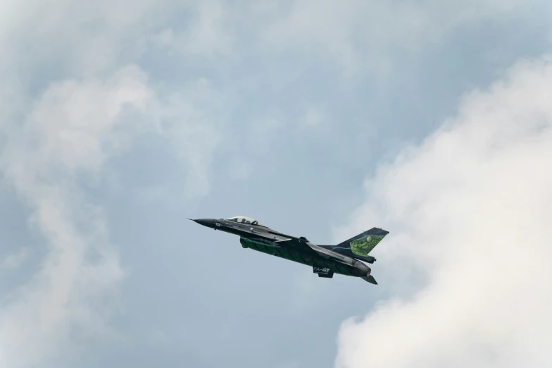 a fighter jet flying through the sky on a cloudy day