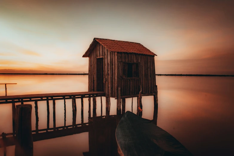 a wooden cabin sitting on top of a pier near a body of water