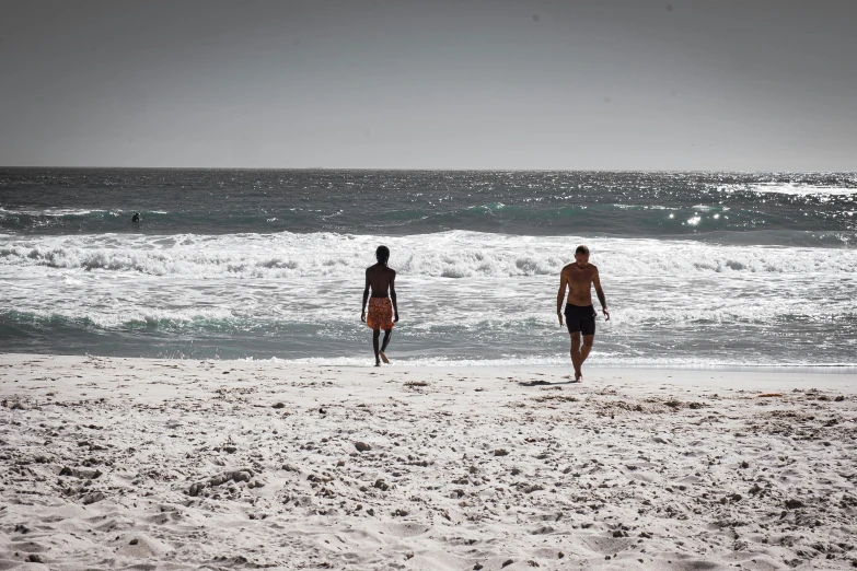 a couple of men that are standing in the sand