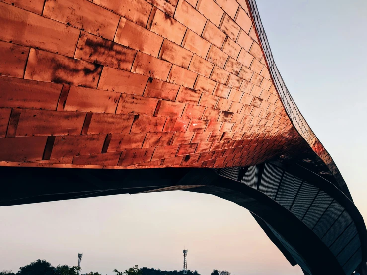 the view under a bridge that crosses the river in front of the sunset