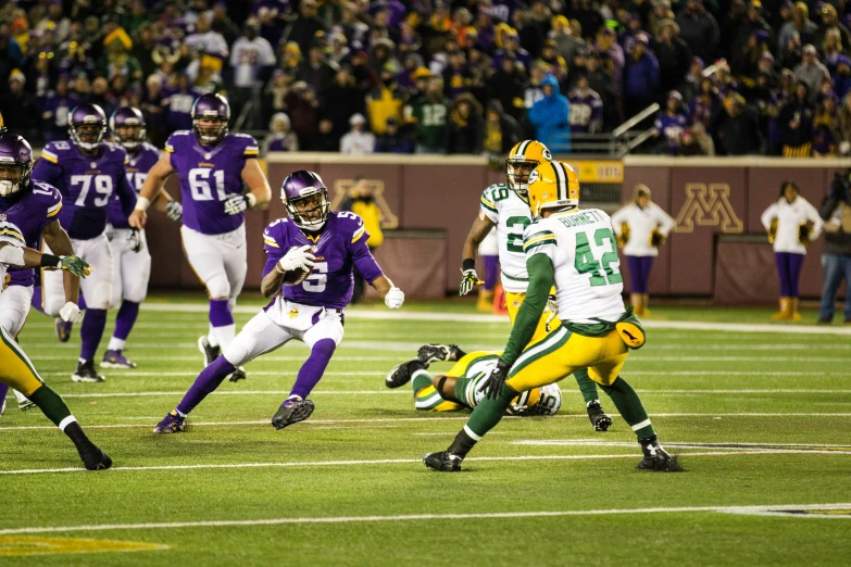 a green bay running for a yard as two other teams watch