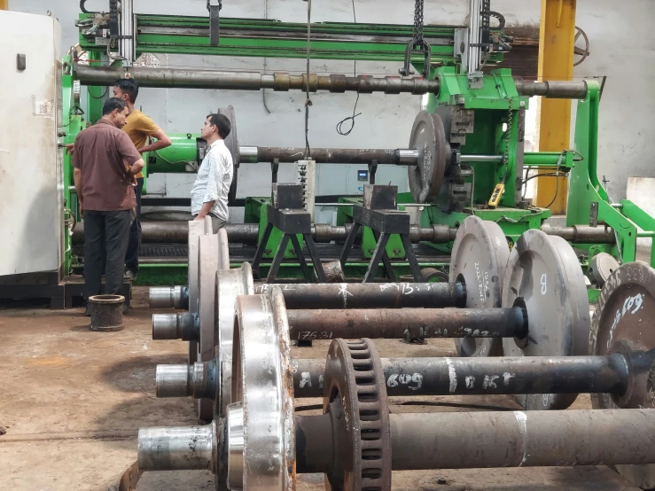 two workers inspect a machine in a factory