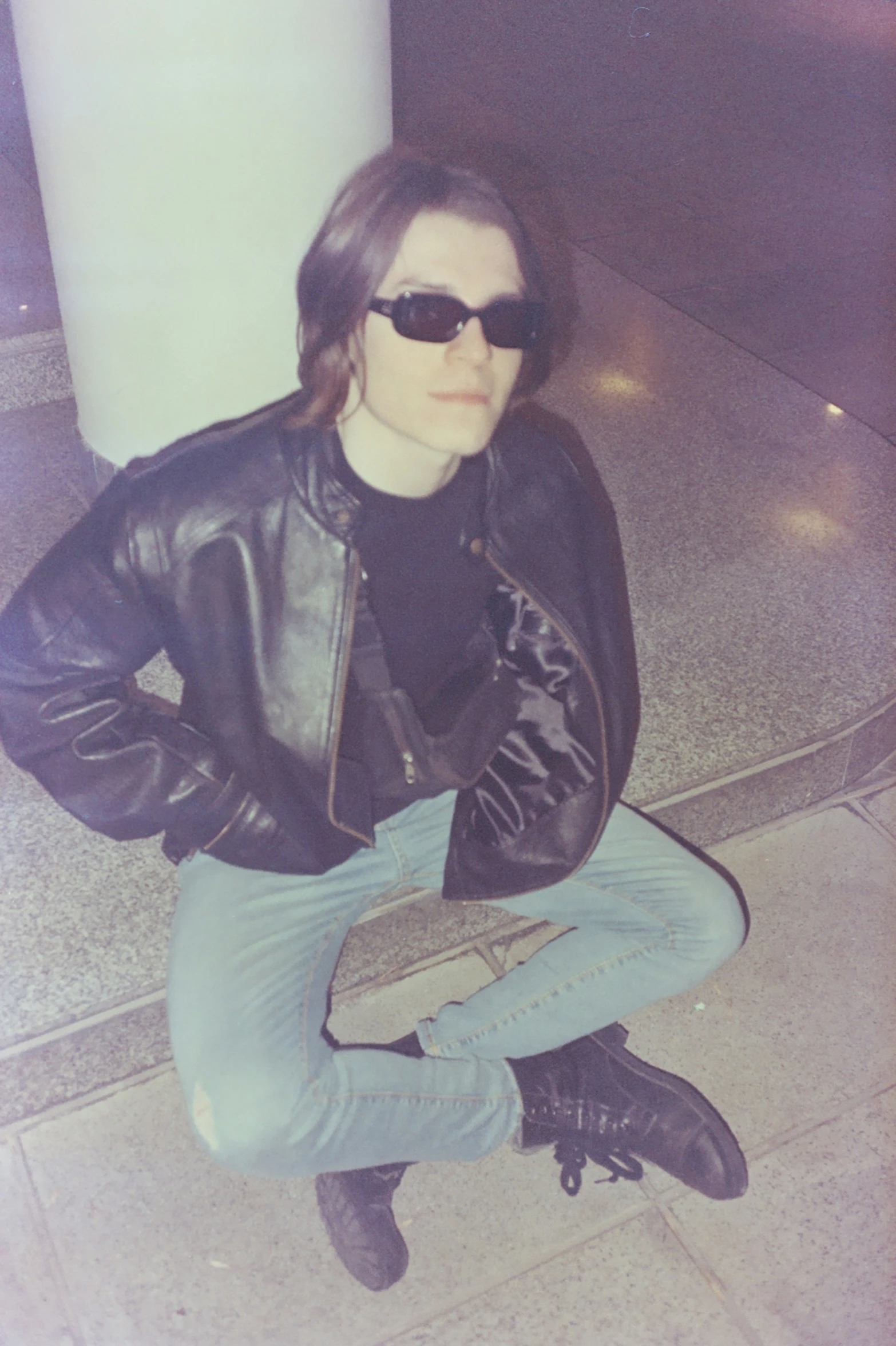 a woman sitting on the ground wearing sunglasses