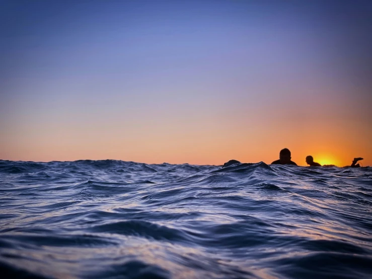 there is a person riding a surf board at sunset