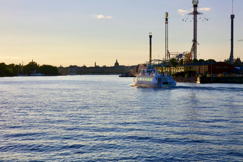 a ship in the water passing by two power plant towers