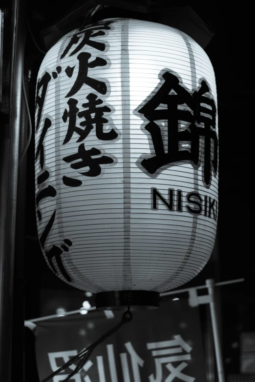 chinese lantern hanging outside at night with writing written in different languages