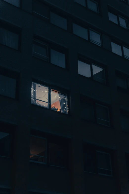 a dark black building with some windows and people in it