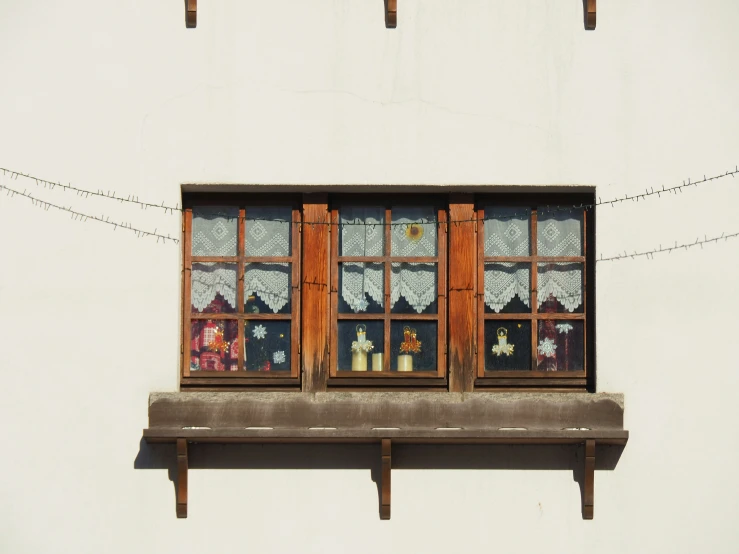 two wooden windows sit on a concrete ledge