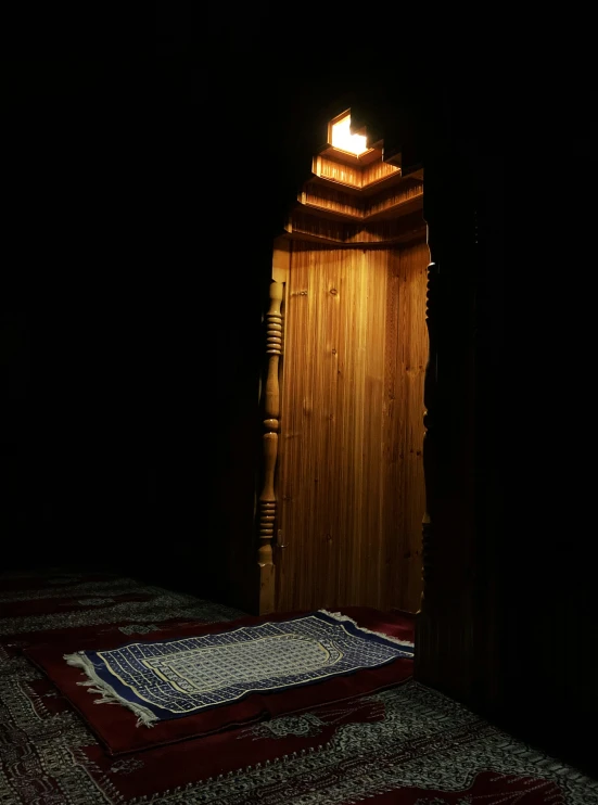 a lit doorway and wooden door frame in a dark room
