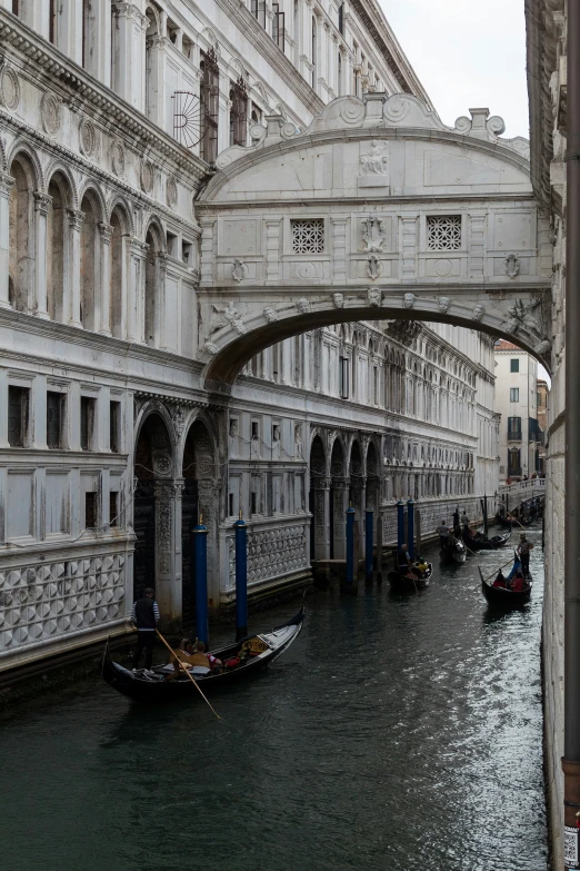 a bridge spanning a large waterway with a row of boats