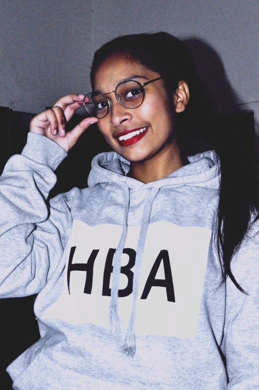 a woman wearing a hooded sweatshirt and glasses