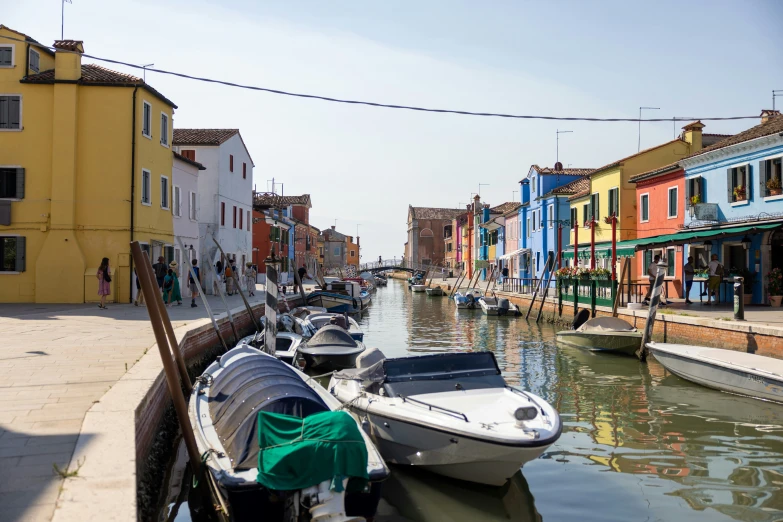 a row of boats sit in a marina next to buildings