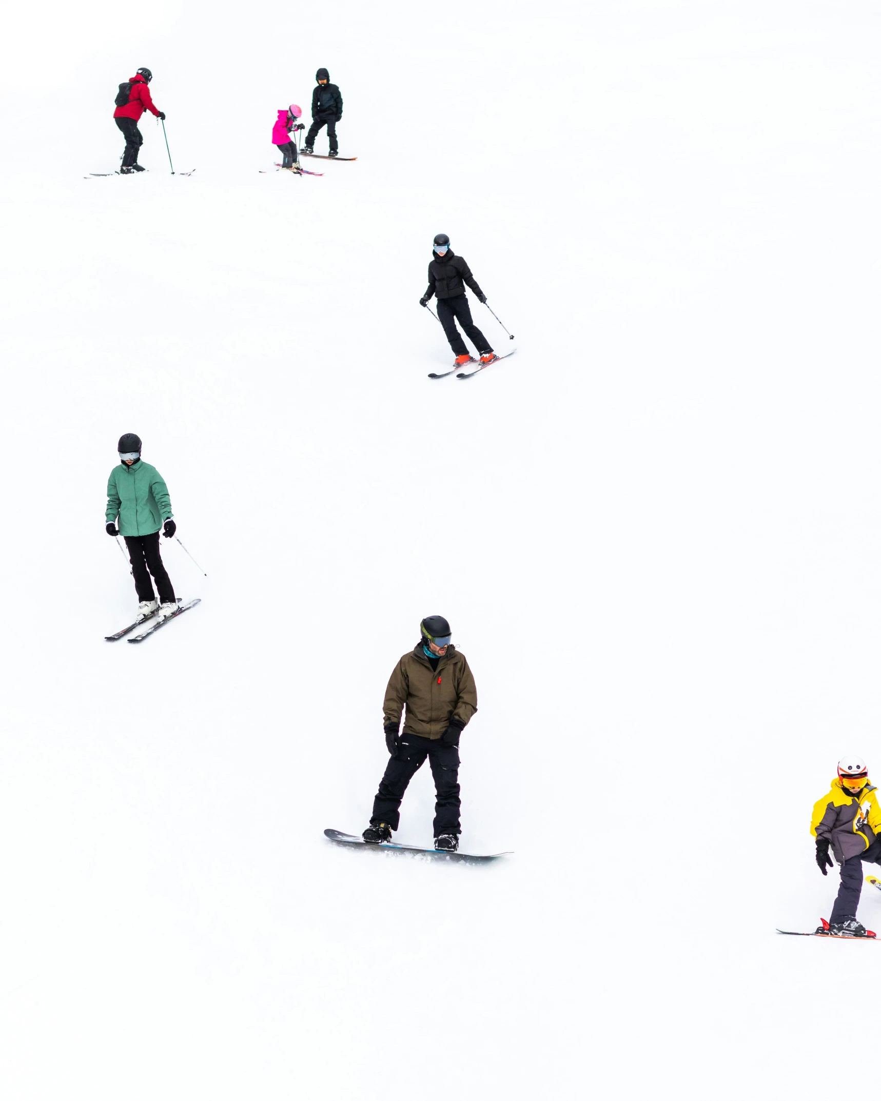 a group of people riding snowboards down a ski slope