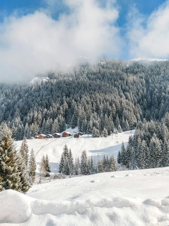 the snow is melting and mountains are covered in clouds