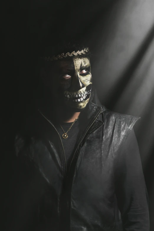 a man is dressed in black and is covered in golden paint