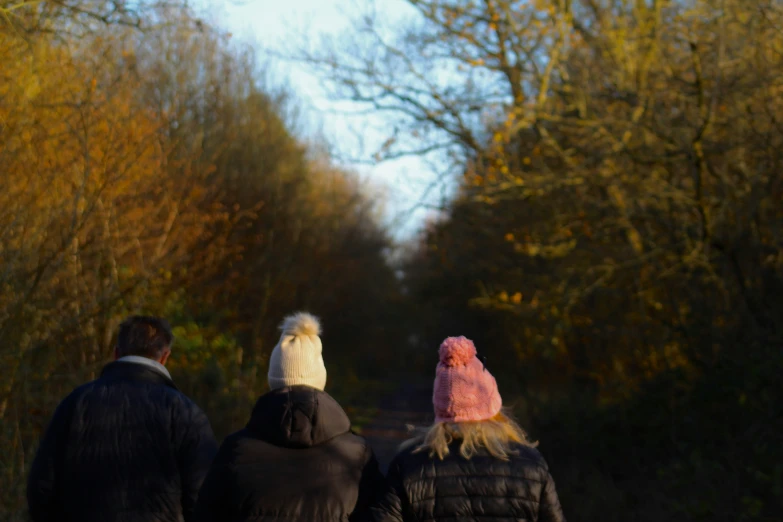 two people walk down a path in the woods