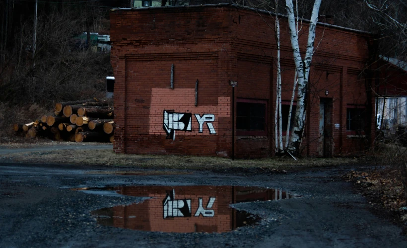 graffiti on a red brick building near trees