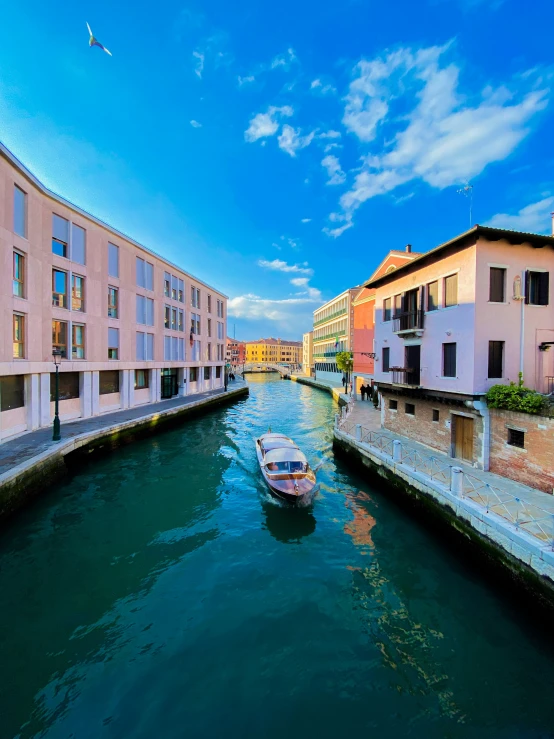 boats are riding down a waterway with buildings in the distance