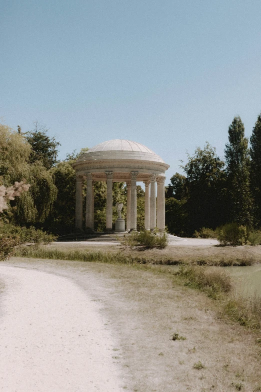 a gazebo in a rural park surrounded by trees and bushes