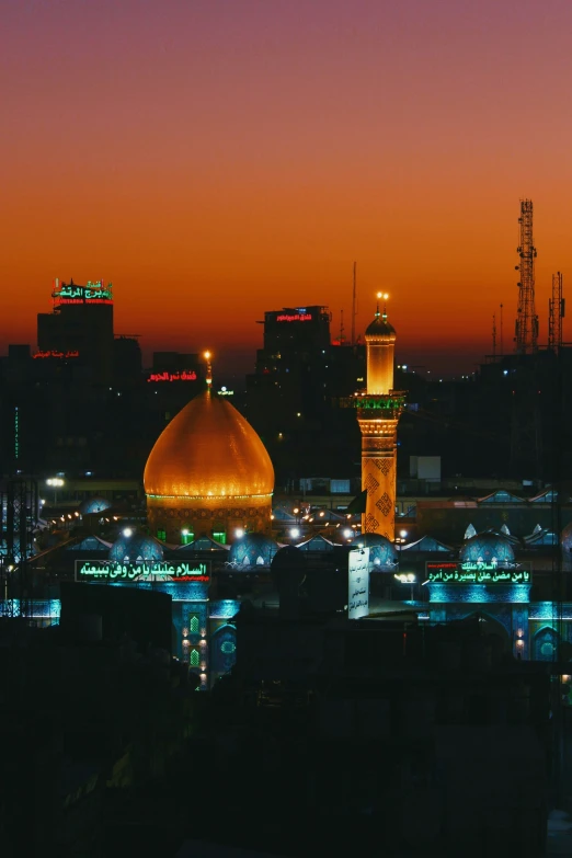 an evening cityscape shows a building with some domes and lights