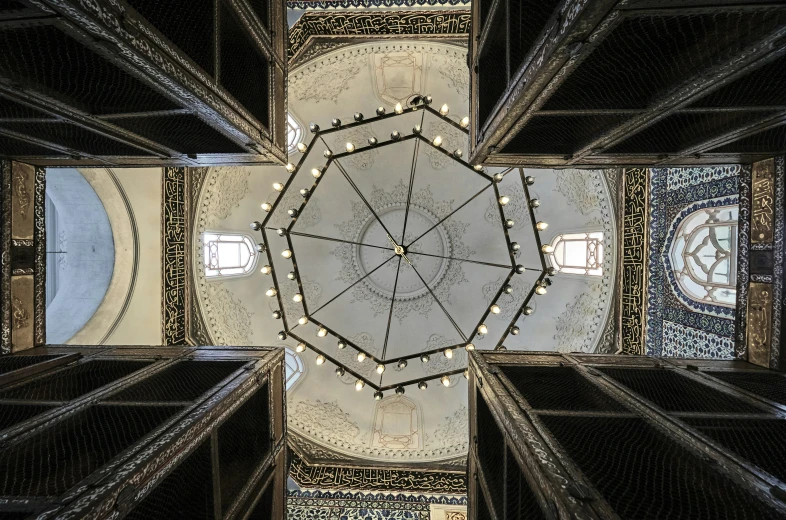 looking up at an intricate circular mirror inside a building