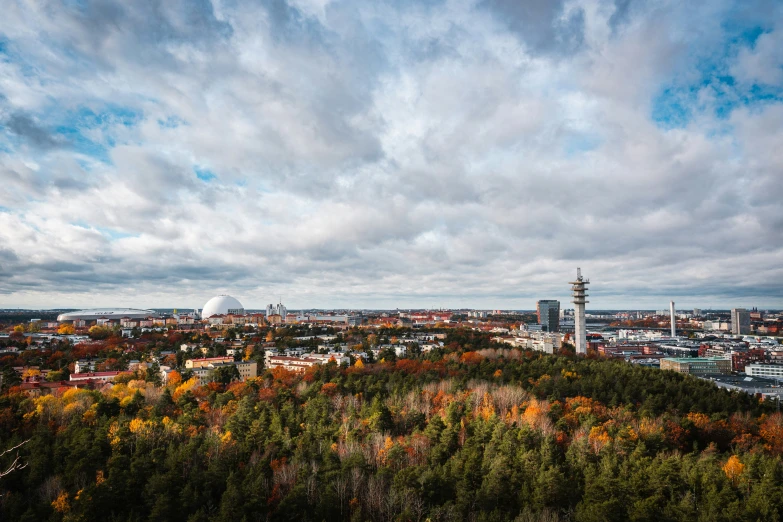 clouds and blue sky over a cityscape with trees and other buildings