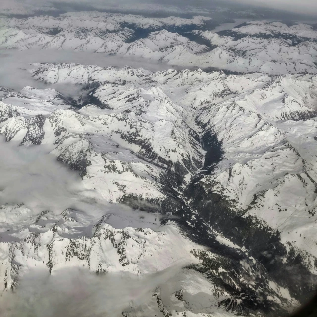 a picture taken from an airplane looking down at snowy mountains