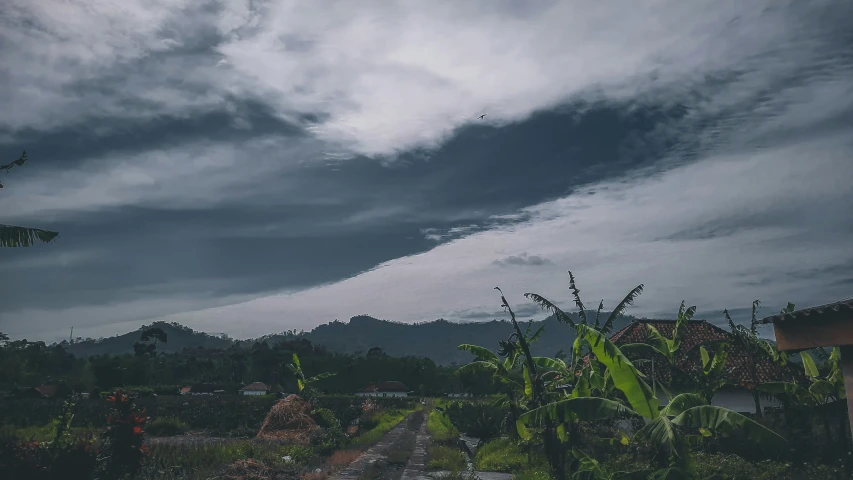 dark clouds float above a landscaped landscape