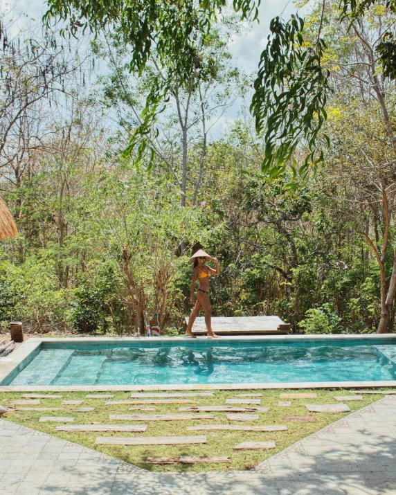 a person is standing near a large pool