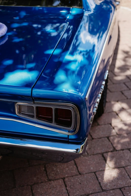 an old style muscle car is parked on the side of a street