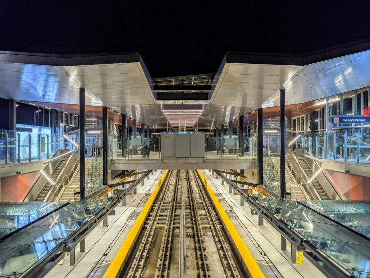 a long, narrow subway train station with a full escalator