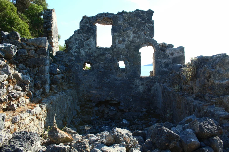 a couple of windows are in the wall of an old brick building