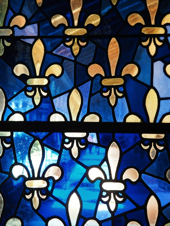 a close up of a glass with gold and blue designs