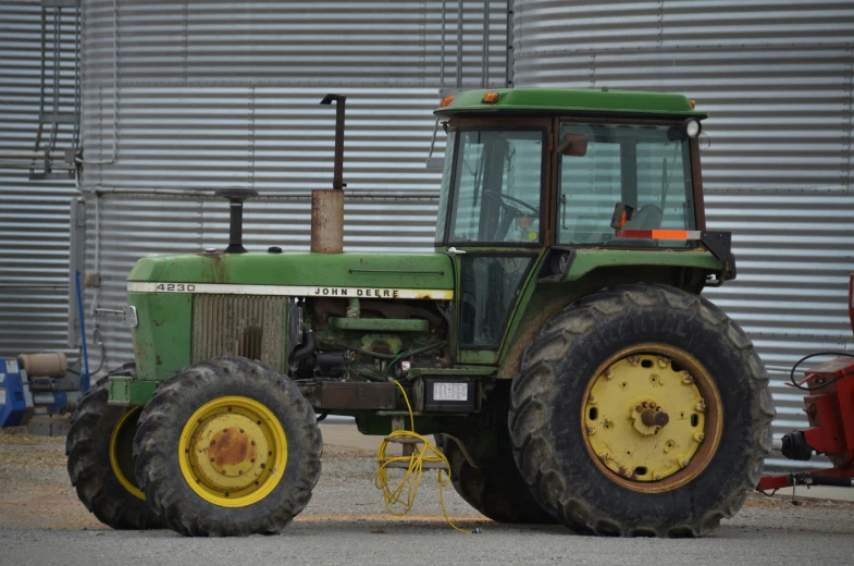 the tractor has big tires and is ready to pick up grain