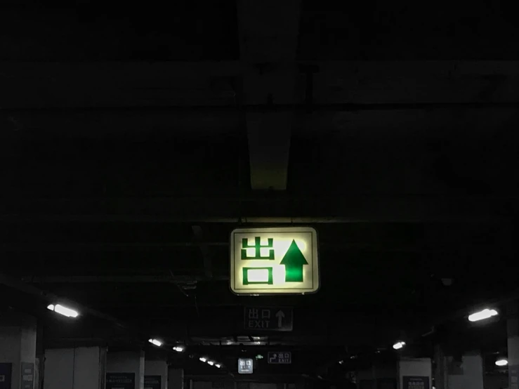 a dark picture of an exit sign with people inside