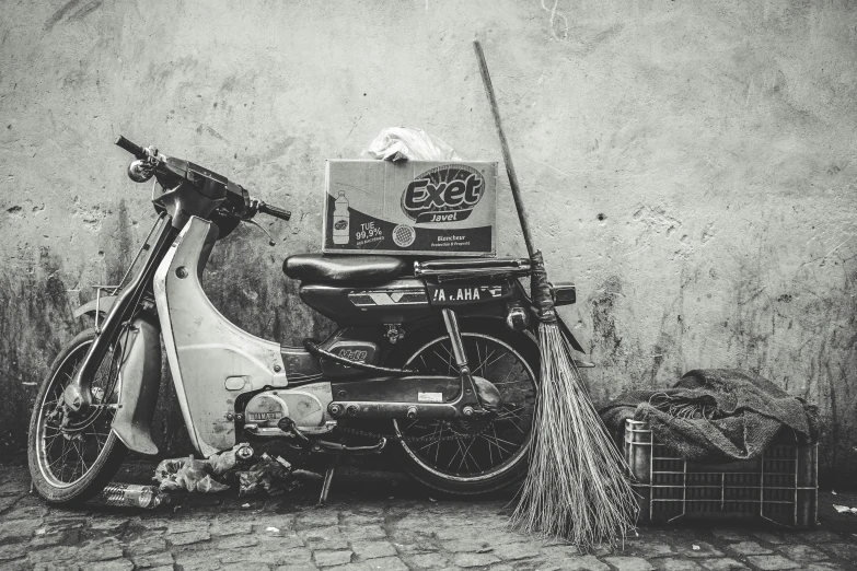 a motor scooter with a christmas tree leaning on it next to a wall