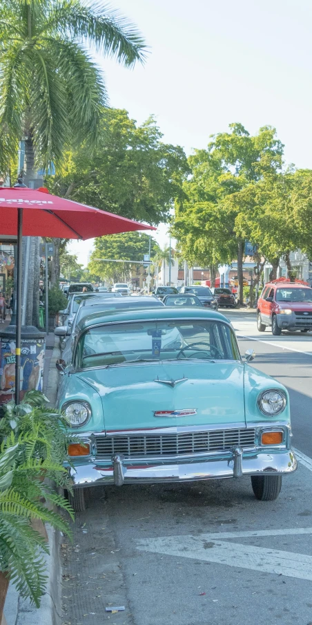 there is an old antique car that is parked by the street