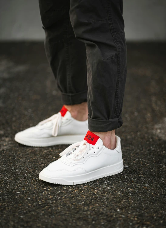 the feet of a man in sneakers on asphalt