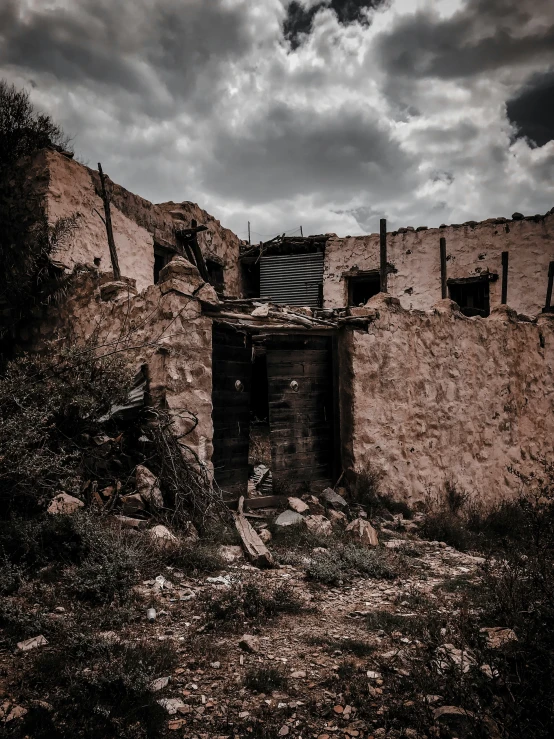 an old ruin building sitting on a hill side