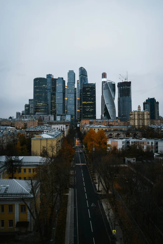 a very tall city with buildings and the road running through it