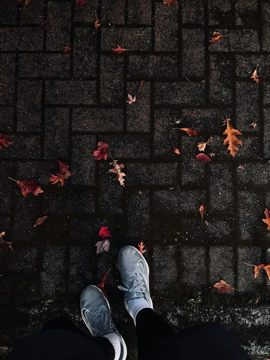 a person in the rain is standing by a wall