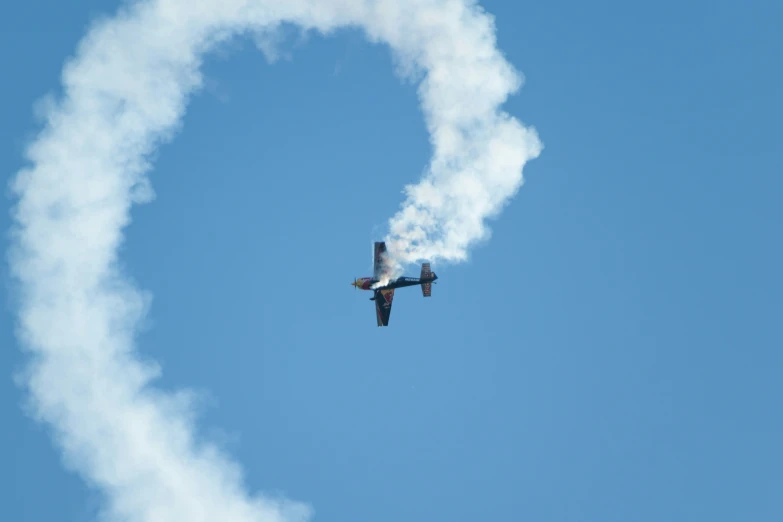 a small air plane flying through the blue sky