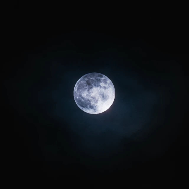 a full moon in the dark sky above