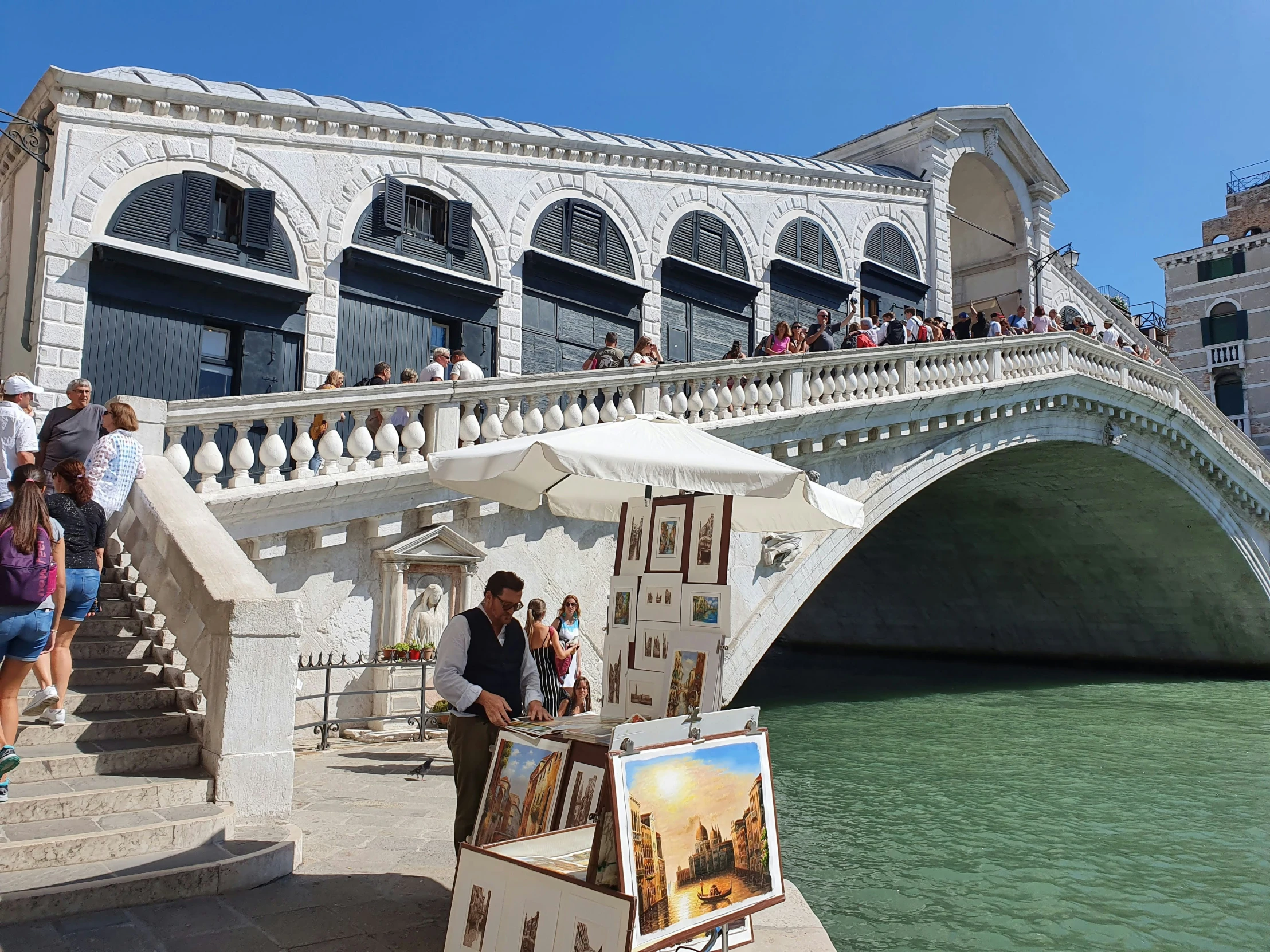 a bridge with people walking across it in front of a building