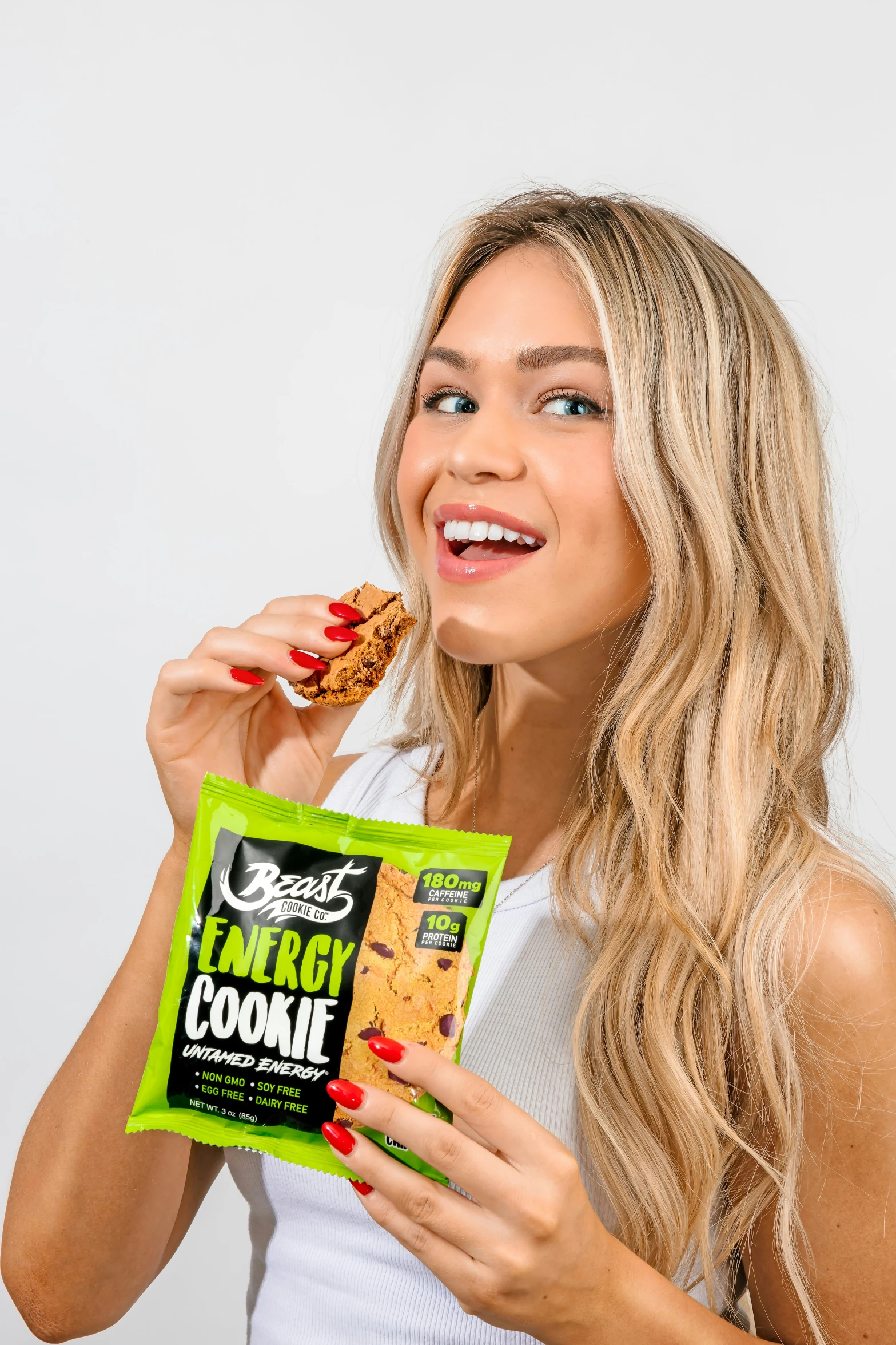 a blonde woman eating cookies with a packet of ers